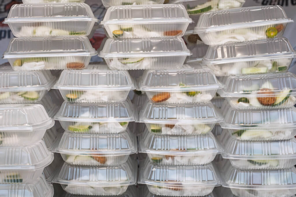 Stacks of plastic to-go containers prepared by a catering company