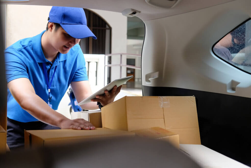 A delivery driver is scanning a package as he completes a same day delivery